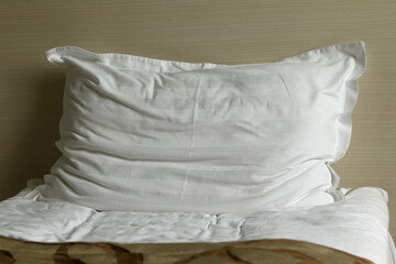 A crumpled pillow on a hotel bed