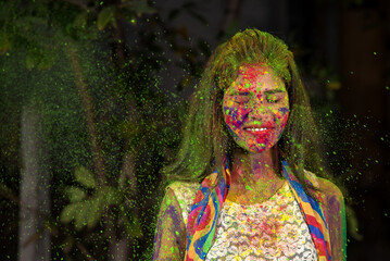 Fototapeta premium A young girl plays with colors. The concept for Indian festival Holi. color splash.