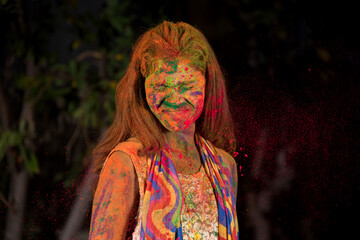 A young girl plays with colors. The concept for Indian festival Holi. color splash.