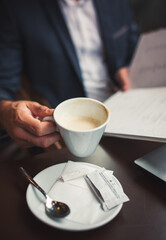 Close up view of businessman holding cup of coffee