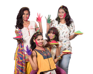 Group of happy young girls having fun with colorful powder at Holi festival of colors