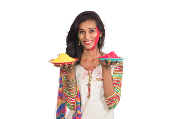 Beautiful young girl holding powdered color in plate on the occasion of Holi festival.