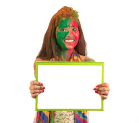 Girl holding a white signboard with face painted with color in Festival of Colour Holi. Isolated portrait