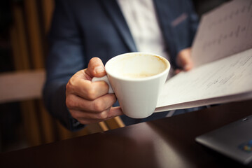 Close up view of businessman holding coffee cup