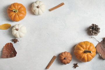 Thanksgiving flat lay background with seasonal autumn decoration, top view of pumpkins and leaves for fall holiday.