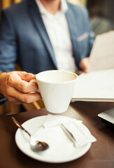 Close up view of businessman holding cup of coffee