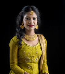 Portrait of beautiful traditional Indian girl posing on black background.
