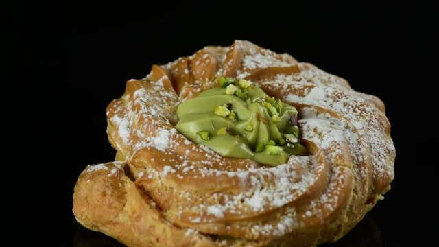 Close up delicious italian desserts with pistachio cream called zeppole of St. Joseph on black background, zoom in. Zeppole is an apulian traditional pastries for celebration of Fathers day