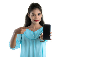 Young Indian girl using a mobile phone or smartphone isolated on a white background