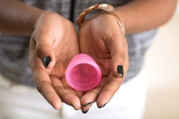 Fototapeta premium Close-up of young girl hands holding menstrual cup, Gynaecology concept, Showing thumbs up approving the use of the menstrual cup