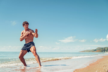 Fototapeta na wymiar A muay thai or kickboxer training with shadow boxing outdoor at seashore