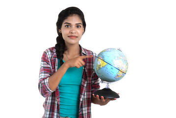 young woman holding the world globe and posing on a white background.
