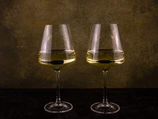 two long-stemmed glasses with white wine