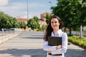 Fototapeta premium Happy adult student poses looking at camera on college campus.Senior and street student concept.