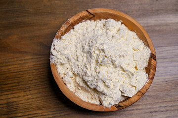 flour in a wooden dish on the kitchen table. 