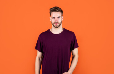looking so trendy and fresh. male beauty and fashion. serious guy on orange background.