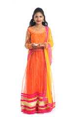 Beautiful Indian young girl holding pooja thali or performing worship on a white background