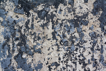An old concrete wall with peeling burnt paint