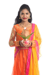 Indian Woman holding a traditional copper kalash, Indian Festival, copper kalash with coconut and mango leaf with floral decoration, essential in hindu puja.