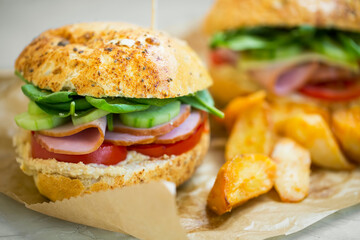 Healthy sandwich with ham, lettuce, cucumbers,tomatoes vegetables with wedges potatoes