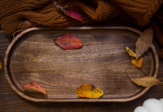Autumn composition. Photo wooden tray frame with leaves and  cosy wool cardigan . Autumn, fall, thanksgiving day concept. Flat lay, top view, copy space