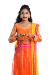 Fototapeta premium Portrait of a Indian Traditional Girl holding Diya, Girl Celebrating Diwali or Deepavali with holding oil lamp during festival of light on white background