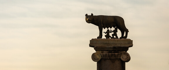 The statue of the Capitoline Wolf with Romulus and Remus and the Coliseum in background, Rome, Italy
