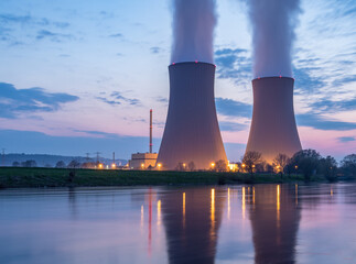 Nuclear power plant against sky by the river at sunset - obrazy, fototapety, plakaty