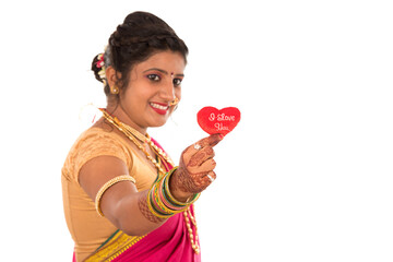 Traditional Beautiful Indian young girl in saree posing with Heart on white background