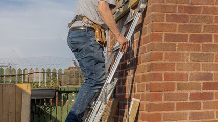 Builder climbing a ladder to work