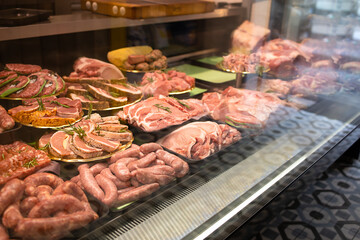 Showcase with raw farmer meat in butcher shop