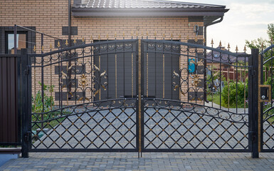 Transparent metal forged gates in front of the entrance to the garage