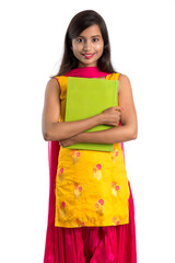 Pretty young girl holding book and posing on white background