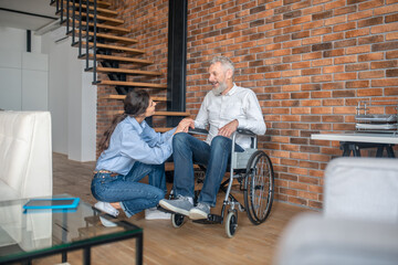 Obraz premium Dark-haired young woman sittingnear her handicapped husband