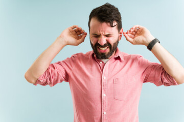 Fototapeta premium Attractive man feeling pain while cleaning his ears