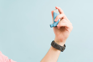 Close up of a man with an asthma inhaler - obrazy, fototapety, plakaty