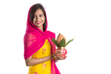 Indian girl holding a traditional copper Kalash, Indian Festival, copper Kalash with coconut and...