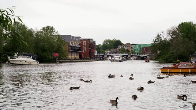 People having a good time on a small boats cruising down the River Thames on cloudy weekend