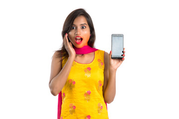Young beautiful woman holding and showing blank screen smartphone or mobile or tablet phone on a white background.