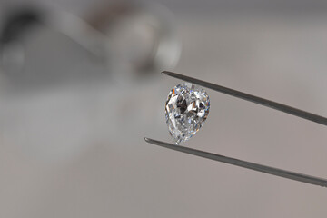 Close up of diamond dealer's hands evaluating diamond at international jewelry exhibition. High...