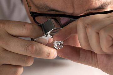Close up of diamond dealer's hands evaluating diamond at international jewelry exhibition. High quality photo - obrazy, fototapety, plakaty
