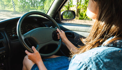 a brunette in jeans is driving an old Japanese car with a right hand drive