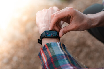Hiker using heart rate monitor training running, smartwatch checking performance or GPS. Traveller...