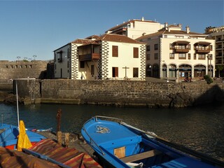 Fototapeta na wymiar Panorama mit Häusern, Meer und Fischerbooten am Hafen in Puerto de la Cruz