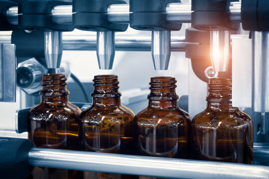 pharmaceutical industry, medicine pills are filling in the  glass bottle on production line machine conveyor at the medical factory. selective focus.