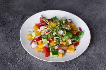 Wheat germ salad, tomatoes, peppers, radish, cucumber, olive oil. Vegetable salad on white plate on gray background