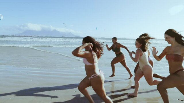 Different sized women running race on beach