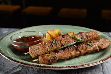 Grilled meat skewers, shish kebab on wooden table dark background copy space closeup