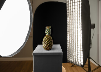 This fun whole pineapple fruit image is isolated on a diagonally split darker colored green and...