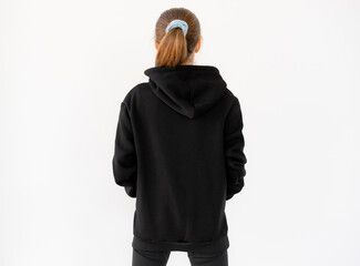 Back view of girl wearing black hoodie isolated on white background